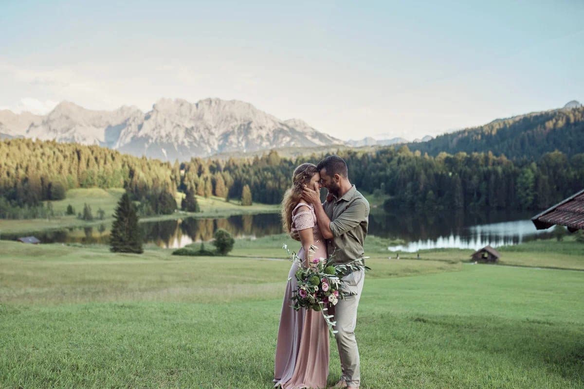 Couple holding hands in front of Lake Geroldsee with the Karwendel mountains during a couple photoshoot in Bavaria